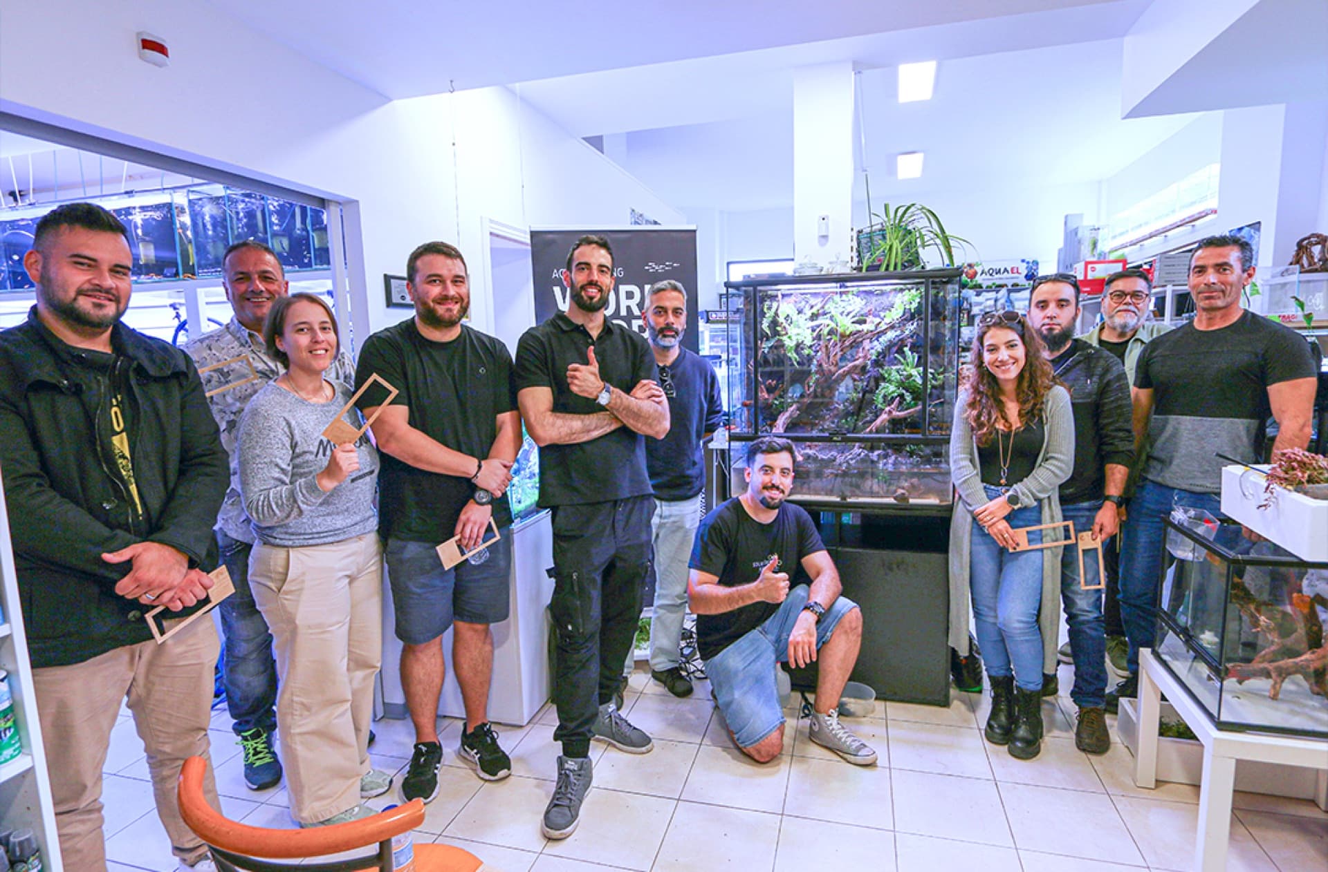 Detalhe de mãos a plantar num aquário durante um workshop